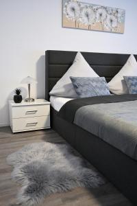 una camera da letto con un letto e un comodino con un cassetto bianco di Timos Ferienwohnung a Schmallenberg