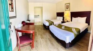 een hotelkamer met twee bedden en een bureau en een bureau bij Niagara Best Inn in Niagara Falls