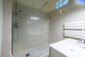 a white bathroom with a shower and a sink at Votre famille à Périgueux Charme & Confort in Périgueux +4 photos