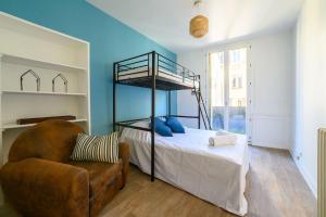 a bedroom with a bunk bed and a chair at Votre famille à Périgueux Charme & Confort in Périgueux