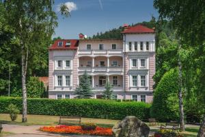 un gran edificio rosa con techo rojo en Willa Arabeska, en Lądek-Zdrój