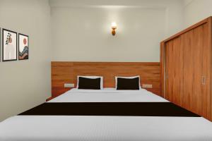 een slaapkamer met een groot bed met een houten hoofdeinde bij Hotel O Royal Stay in Hirisāve