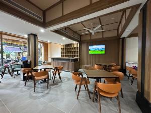 a restaurant with tables and chairs and a tv at A25 Premium Hotel - 21 Nghia Tan in Hanoi +8 photos