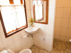 een badkamer met een wastafel en een toilet en een raam bij Huan Aumpron Resort in Ban Kha Ngam