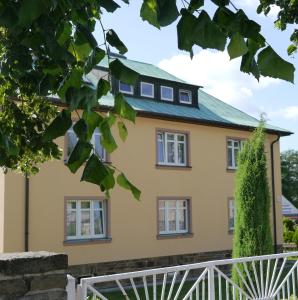 una casa amarilla con techo verde en Ferienwohnung Kaufmann, en Sehma