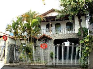 a house with a gate in front of it at Chale Mineiro Hostel & Pousada in Belo Horizonte