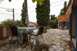 a patio with a table and chairs and a tree at Apartments Rialto in Veli Lošinj