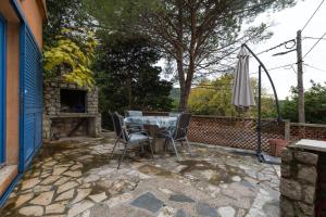 a patio with a table and chairs and an umbrella at Apartments Rialto in Veli Lošinj +79 photos