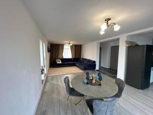 a living room with a table and chairs and a couch at ZenHome in Craiova
