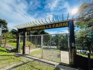 a gate with a sign that reads the pinealls farm at The PineHill Farm in Tanay