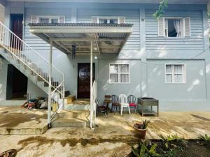 a white house with a staircase and a table at The PineHill Farm in Tanay