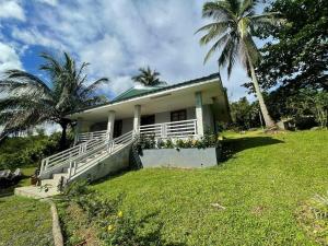 a small white house with a palm tree in a field at The PineHill Farm in Tanay +44 photos