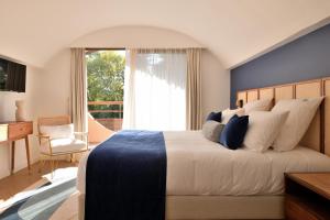 a bedroom with a large bed with a blue wall at La Réserve Esterel in Saint-Raphaël