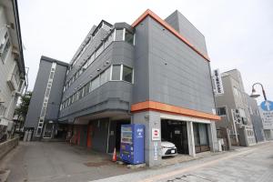 un bâtiment avec une voiture garée devant dans l'établissement BetterЯ03青森橋本203号室, à Aomori