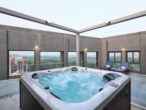 a jacuzzi tub in a room with windows at Pride Elite Gandhinagar in Gandhinagar