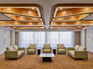 a waiting room with chairs and a table at Pride Elite Gandhinagar in Gandhinagar