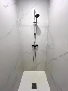 a white bathroom with a shower with a toilet at La Petite Escapade-Free Parking in Liège