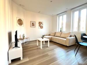 a living room with a couch and a tv at La Petite Escapade-Free Parking in Liège