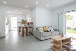 a living room with a couch and a table at Villa Le Manguier - Logement Manka, Piscine privée in Goyave