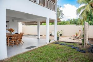 an outdoor patio with a table and chairs at Villa Le Manguier - Logement Manka, Piscine privée in Goyave