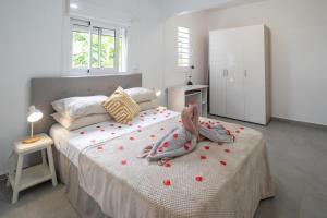a bedroom with a bed with red hearts on it at Villa Le Manguier - Logement Manka, Piscine privée in Goyave +7 photos