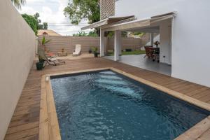 a swimming pool in a backyard with a wooden deck at Villa Le Manguier - Logement Manka, Piscine privée in Goyave