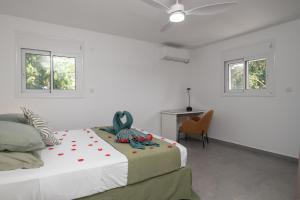 a white bedroom with a bed and two windows at Villa Le Manguier - Logement Marcus, Tout Confort in Goyave