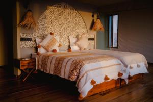 a bedroom with a large bed with a large headboard at SEVEN SAINTS Lodges in El Karia