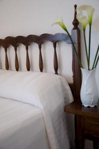 
a white bed with a white bedspread next to a white wall at Hotel Álvarez in Tuéjar
