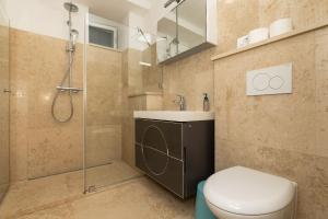 a bathroom with a shower and a toilet and a sink at Apartments Rialto in Veli Lošinj