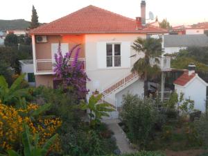a white house with a balcony and some flowers at Apartments Jerkin in Tribunj