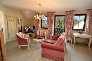 sala de estar con sofá y TV en Villa Rosamunde en Burg (Spreewald)