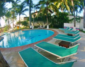 una piscina con sedie a sdraio e palme di Splash Inn Nuevo Vallarta & Parque Acuatico a Nuevo Vallarta