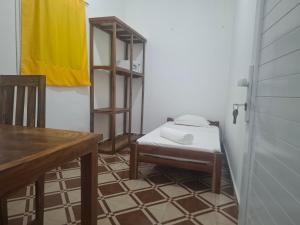 a room with a chair and a table with a yellow towel at Bee Rooms Nosy be in Ambatoloaka