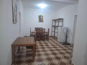 a living room with a table and a refrigerator at Bee Rooms Nosy be in Ambatoloaka