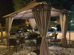 un cenador con mesas y sillas por la noche en Albergo Il Giardino del Rio, en Castel di Sangro