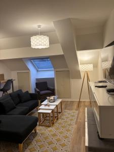 a living room with a couch and a table at Appartement spacieux et élégant in Laon