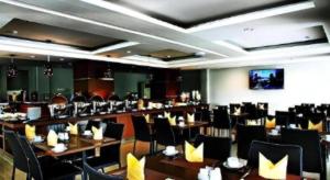 een restaurant met tafels en stoelen in een kamer bij Amantis Hotel in Demak