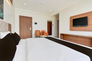 una camera d'albergo con un letto e una TV a schermo piatto di Palette - K9 Family Restaurant a Chākan Altre 28 foto