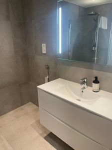 a bathroom with a white sink and a mirror at Hotell Sjyen in Nesna +12 photos