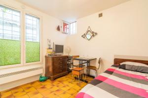 a bedroom with a bed and a desk with a computer at Colonel Fabien Studio in Paris