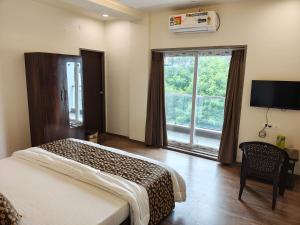 a bedroom with a bed and a large window at RT RESIDENCY HOTEL and LODGE in Nandurbār