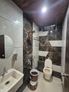 a bathroom with a toilet and a sink at RT RESIDENCY HOTEL and LODGE in Nandurbār