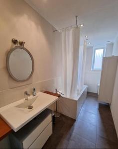 a bathroom with a sink and a mirror and a tub at Süße Marie 3 in Karlsruhe