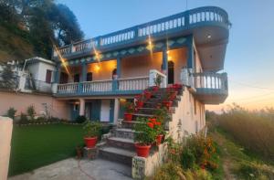 a house with stairs and potted plants on it at The Gypsy Soul Mukteshwar in Mukteshwar