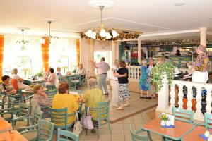 a group of people sitting at tables in a restaurant at Spa & Wellness Hotel Harmonie in Mariánské Lázně