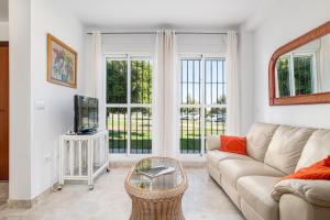 a living room with a couch and a tv at Rincón del Sur in Vejer de la Frontera