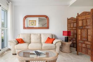 a living room with a couch and a mirror at Rincón del Sur in Vejer de la Frontera
