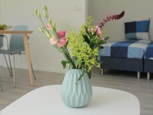 un vaso bianco pieno di fiori su un tavolo di Stunning apartment in Schoorl, North Hollandâ you can bike to the beach a Schoorl