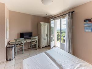 een slaapkamer met een bed en een bureau met een computer bij D de Camiole A N102 ST2 in Callian